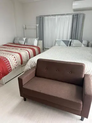 a bedroom with a bed and a chair next to it at QQ Umeyashiki in Tokyo
