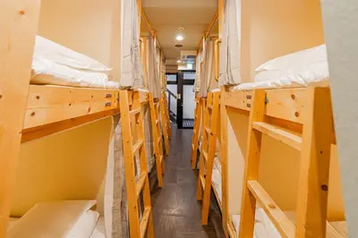a hallway of a dorm room with multiple bunk beds at E JOY INN-East Nipoori Branch in Tokyo