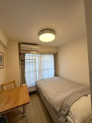 a bedroom with a bed and a table and a window at Garden square in Tokyo