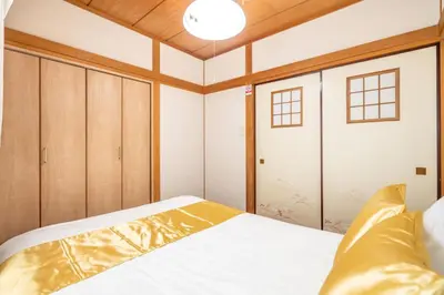 a bedroom with a white bed and wooden ceilings at KYARA Hotel \u767d\u9ce5 in Tokyo