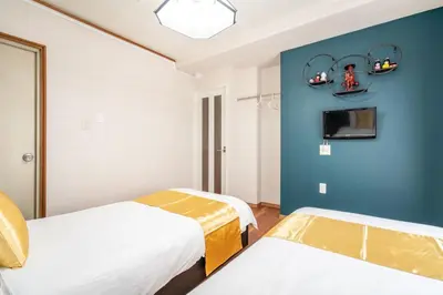 a bedroom with two beds and a blue wall at KYARA Hotel \u767d\u9ce5 in Tokyo