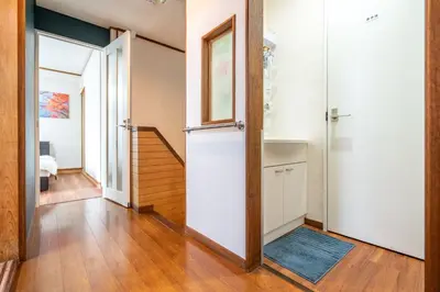 a hallway with an open door and a stairway at KYARA Hotel \u767d\u9ce5 in Tokyo