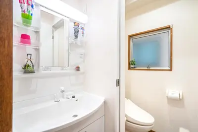 a white bathroom with a sink and a toilet at KYARA Hotel \u767d\u9ce5 in Tokyo
