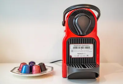 a red toaster next to a plate of chocolates at KYARA Hotel \u6d45\u8349 in Tokyo