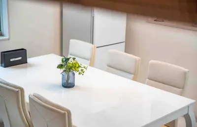 a white table with chairs and a vase of flowers on it at KYARA Hotel \u6d45\u8349 in Tokyo