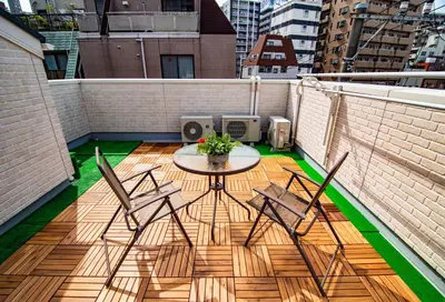 a balcony with a table and chairs on a roof at KYARA Hotel \u6d45\u8349 in Tokyo