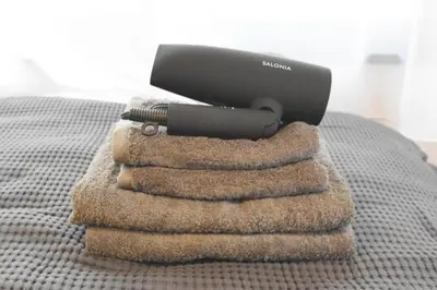 a hair dryer sitting on top of a pile of towels at Ethos Ebisu 201 - Vacation STAY 09298v in Tokyo
