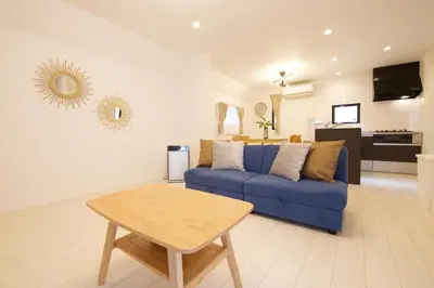 a living room with a blue couch and a table at FINOA Residential Suite Kameari in Tokyo