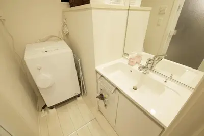 a bathroom with a sink and a washing machine at FINOA Residential Suite Kameari in Tokyo