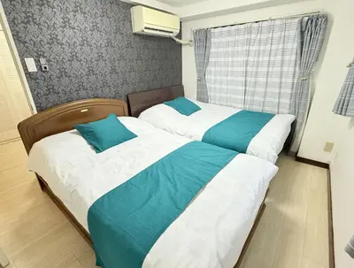 two beds in a bedroom with blue and white at F501 Shinkoiwa Sta 5min Free Wi-Fi Max 5 people in Tokyo
