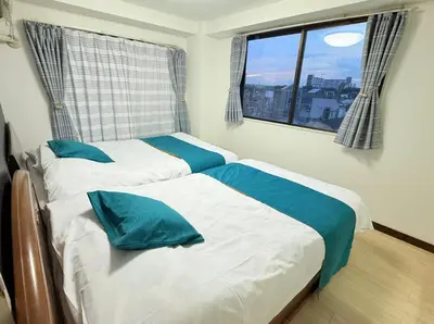 two twin beds in a room with a window at F501 Shinkoiwa Sta 5min Free Wi-Fi Max 5 people in Tokyo