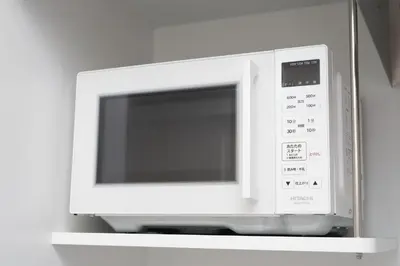 a microwave oven sitting on top of a shelf at IKEBUKURO MANGA HOUSE in Tokyo