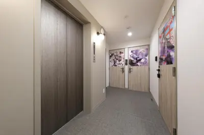 a hallway with wooden doors and a hallway with a hallwayngth at IKEBUKURO MANGA HOUSE in Tokyo