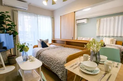 a bedroom with a bed and a table and a tv at Premium Apartment Hotel Tokyo East in Tokyo