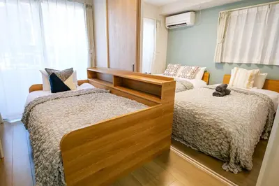 a bedroom with two beds and a large window at Premium Apartment Hotel Tokyo East in Tokyo