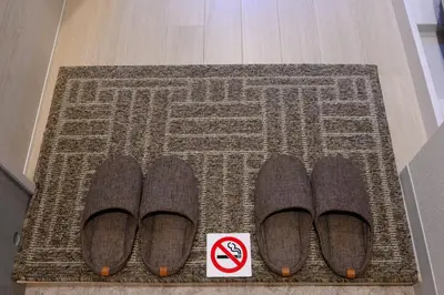 a pair of shoes on a rug with a no smoking sign at Rento Park Shiba301 in Tokyo