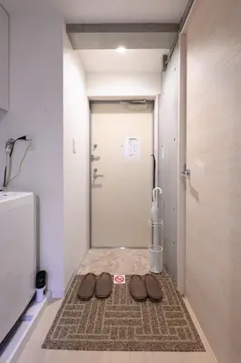 a pair of shoes sitting on a rug in front of a door at Rento Park Shiba301 in Tokyo
