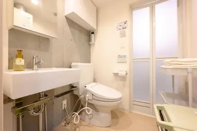 a bathroom with a white toilet and a sink at Rento Park Shiba301 in Tokyo