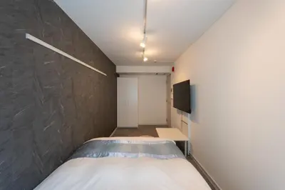 a small bedroom with a bed and a wall at Rento Park Shiba301 in Tokyo