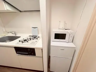 a small kitchen with a stove and a microwave at SQ) SHIBUYA HOUSE in Tokyo