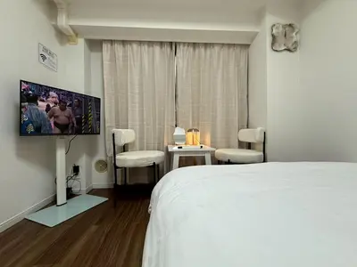 a bedroom with a bed and a flat screen tv at SQ) SHIBUYA HOUSE in Tokyo
