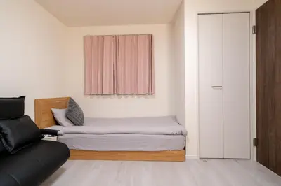 a bedroom with a bed and a couch and a window at Maison Novel under Skytree in Tokyo