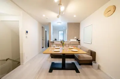 a dining room with a table and a couch at Maison Novel under Skytree in Tokyo