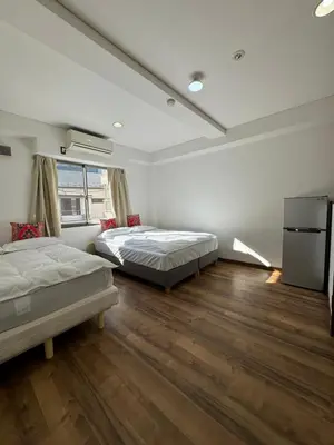 two beds in a room with wooden floors at PAThouse\u53f0\u4e1cAsakusa\u5e97 in Tokyo