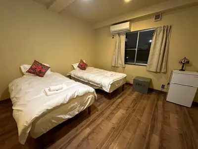 a small room with two beds and a window at PAThouse\u53f0\u4e1cAsakusa\u5e97 in Tokyo
