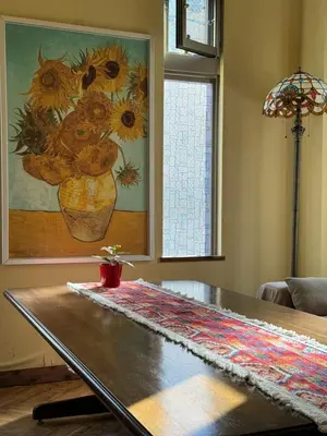 a table in a living room with a painting of sunflowers at PAThouse\u53f0\u4e1cAsakusa\u5e97 in Tokyo
