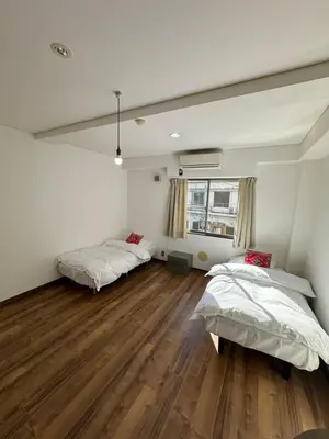 a bedroom with two beds and a wooden floor at PAThouse\u53f0\u4e1cAsakusa\u5e97 in Tokyo