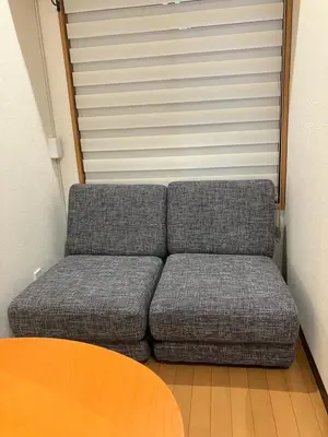 a grey couch in a room with a table at Cube Stay \u5317\u6771\u4eac in Tokyo