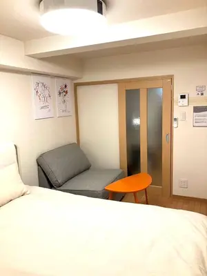a room with a bed and a bench and a table at Cube Stay \u5317\u6771\u4eac in Tokyo