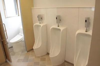 a bathroom with three urinals and a toilet at Hostel Wasabi Asakusa in Tokyo