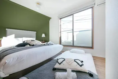 a bedroom with a large bed and a large window at Pufuka Shin nakadori in Tokyo