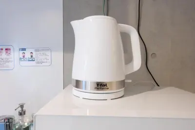 a white coffee maker sitting on top of a refrigerator at Rento Park Shiba 401 in Tokyo
