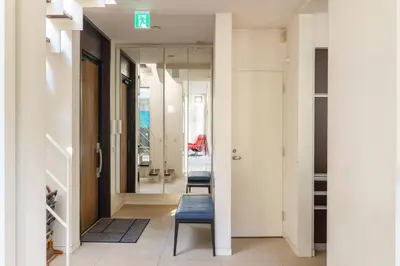 a hallway with two chairs and a mirror at Okusawa Private House in Tokyo