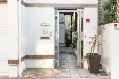 a corridor of a house with white walls and a doorway at Okusawa Private House in Tokyo