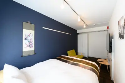 a bedroom with a bed and a blue wall at Rento Park Shiba 501 in Tokyo