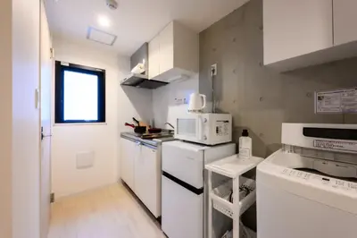 a small kitchen with white appliances and a window at Rento Park Shiba 501 in Tokyo
