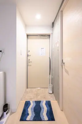 a hallway with a door and a rug at Rento Park Shiba 501 in Tokyo