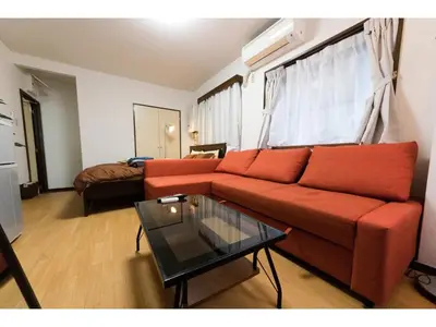 a living room with a red couch and a glass table at Mini Hotel Shinjuku Front - Vacation STAY 89774v in Tokyo