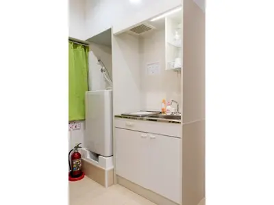 a white kitchen with a refrigerator and a sink at Mini Hotel Shinjuku Front - Vacation STAY 89794v in Tokyo