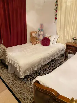 two teddy bears sitting on top of a bed at yiyi tokyo disney minpaku in Tokyo