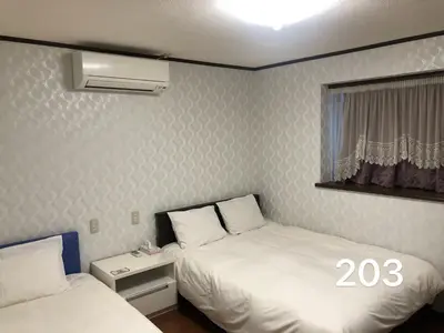 a small room with two beds and a window at \u51a0\u4eac\u30db\u30c6\u30eb in Tokyo