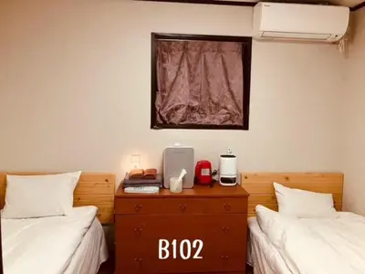 a room with two beds and a desk between them at \u51a0\u4eac\u30db\u30c6\u30eb in Tokyo