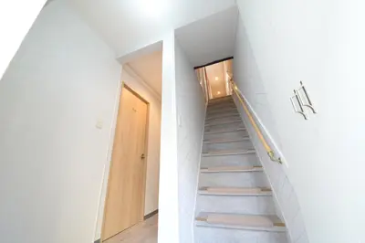 a staircase in a house with white walls at \u548c\u30ce\u6953cottage\u3000\u65b0\u5bbf\u306e2\u968e\u5efa\u30665\u5ba42\u30b7\u30e3\u30ef\u30fc2\u30c8\u30a4\u30ec in Tokyo