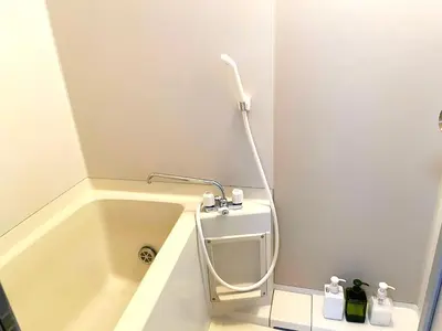 a bathroom with a bath tub with a shower at HARUKAZE HOUSE in Tokyo