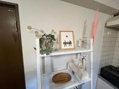 a white shelf with a picture and shoes on it at HARUKAZE HOUSE in Tokyo