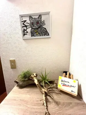 a picture of a cat on a wall next to a branch at HARUKAZE HOUSE in Tokyo